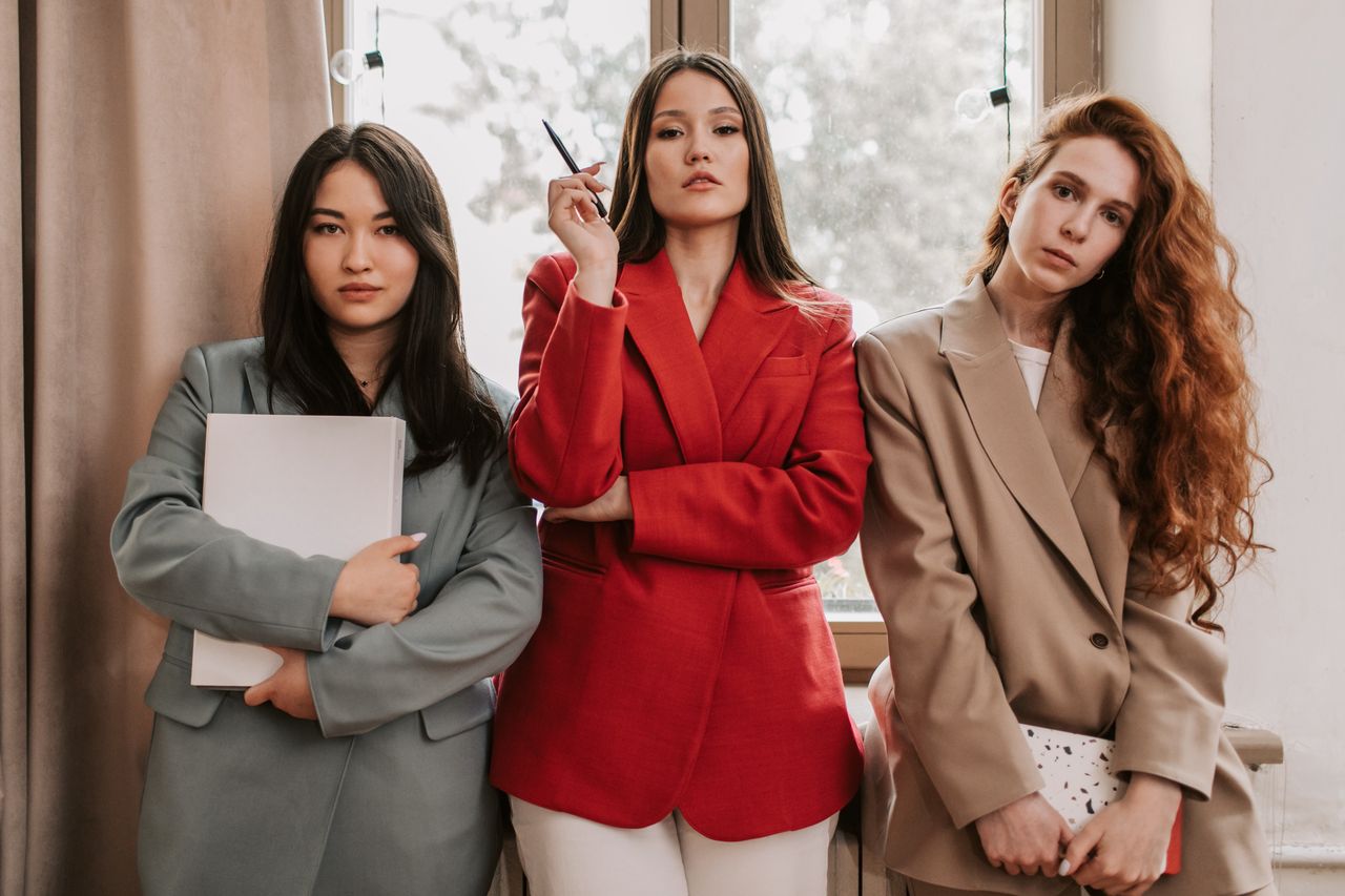 services-01 Three businesswomen in stylish blazers exuding confidence indoors.